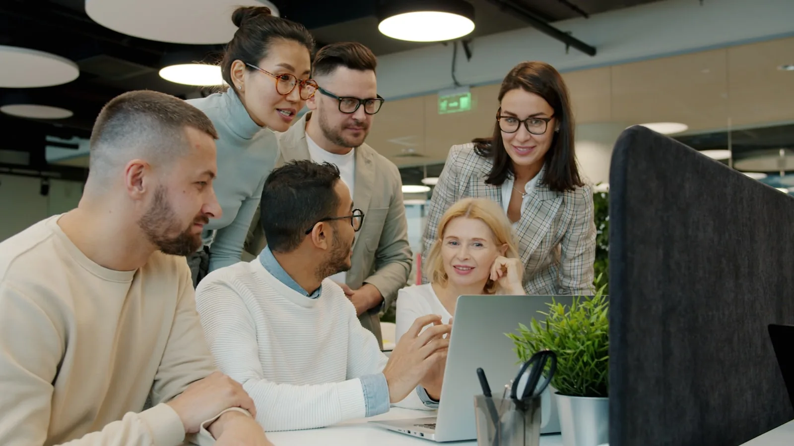 Diverse hiring team reviewing candidate screenings together on a laptop